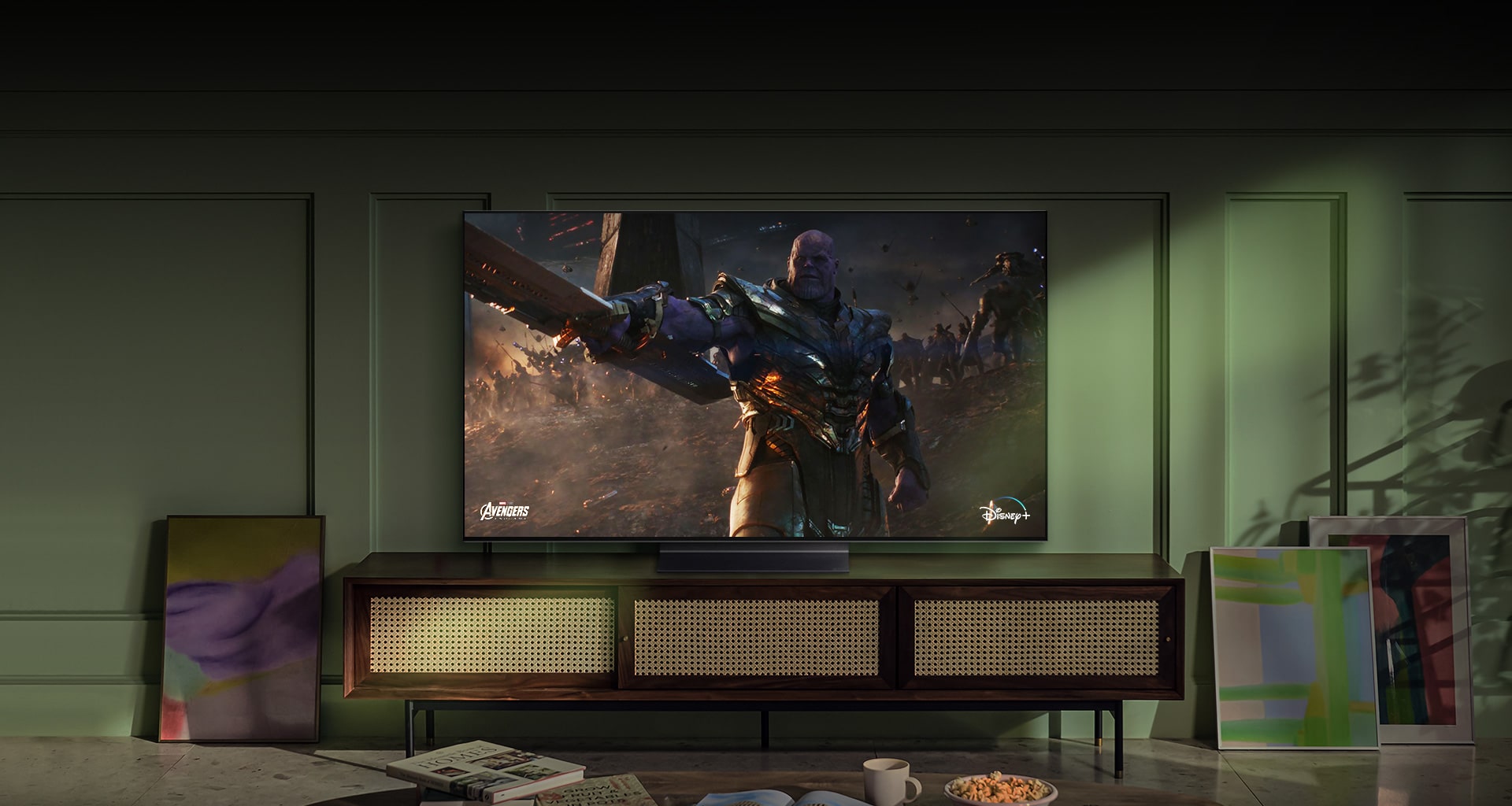 A large wall-mounted LG OLED television shows an action movie scene