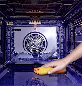 Imagen de un paño limpiando el interior del horno