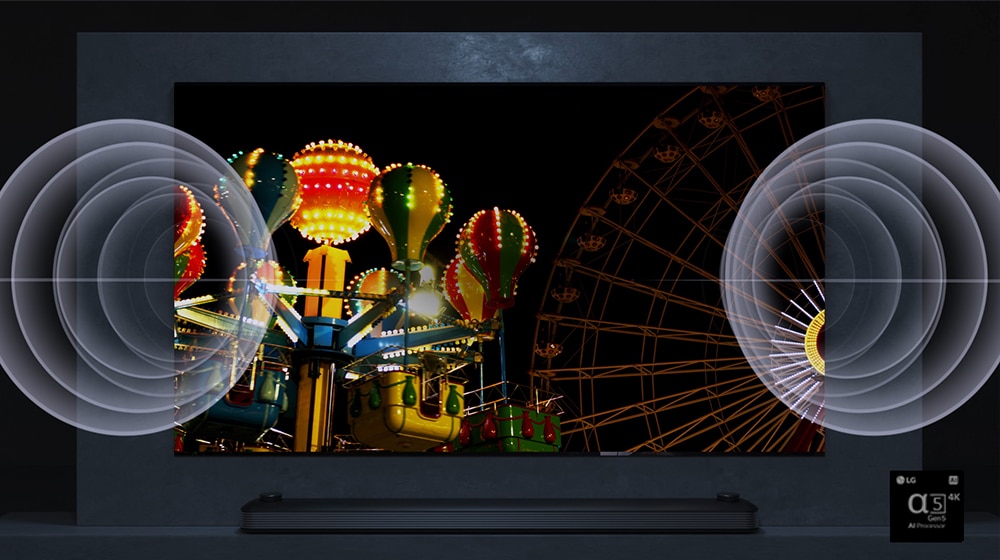 La pantalla de un TV QNED MiniLED de LG muestra la imagen de una atracción de feria con colores muy vivos, y hay , tanto a la izquierda como a la derecha, imágenes que representan una onda sonora.