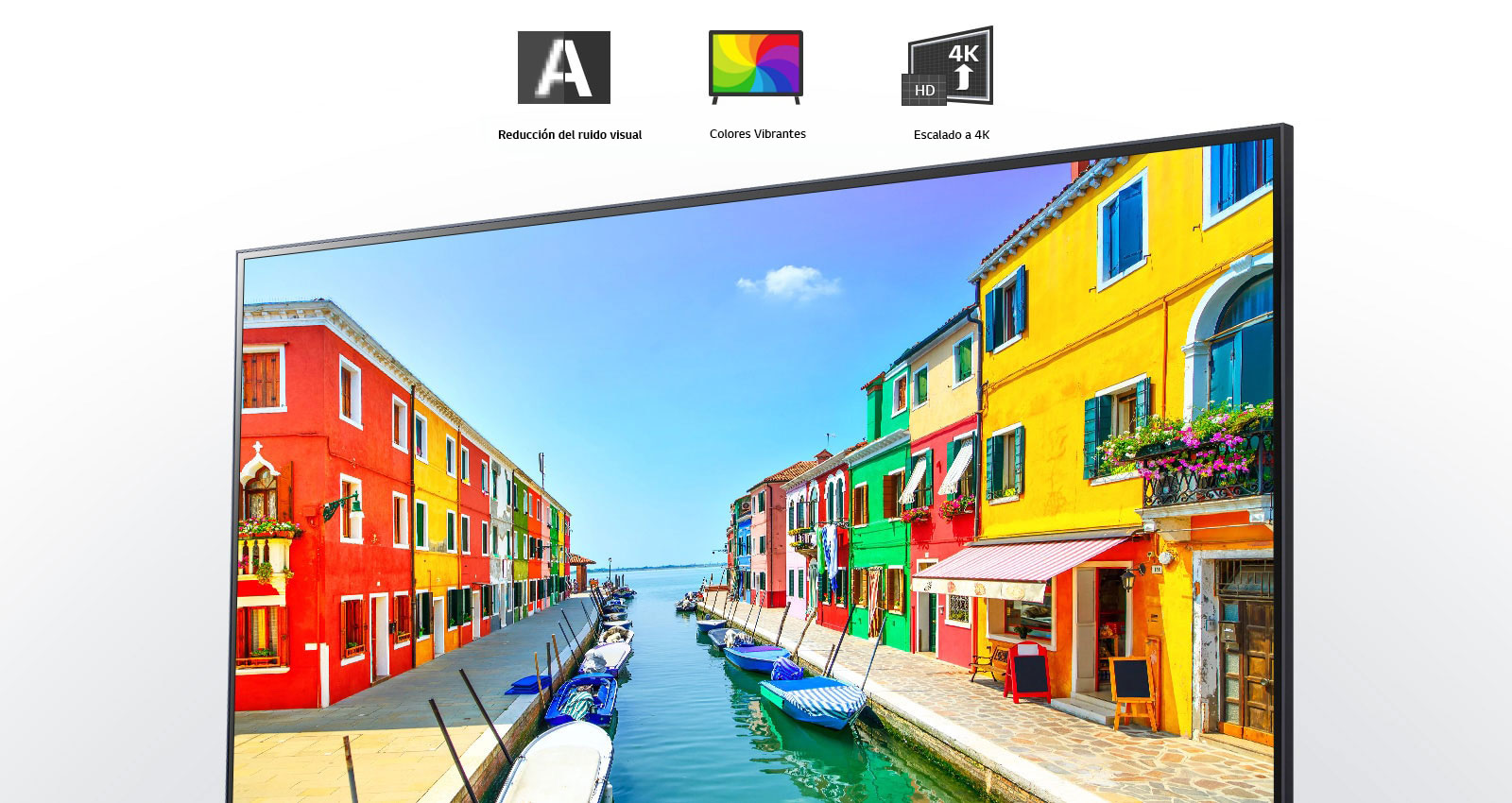 Una pantalla de TV muestra una ciudad portuaria con edificios pintados de múltiples colores y pequeños botes amarrados en un puerto largo y estrecho. 