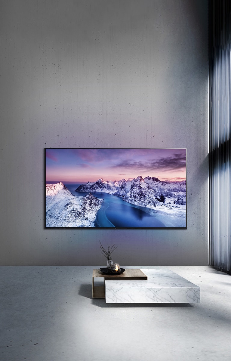 Imagen de un TV UHD en un salón con la imagen de una montaña en su pantalla.