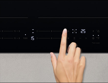 Imagen de mano tocando el panel de control de la placa de inducción.