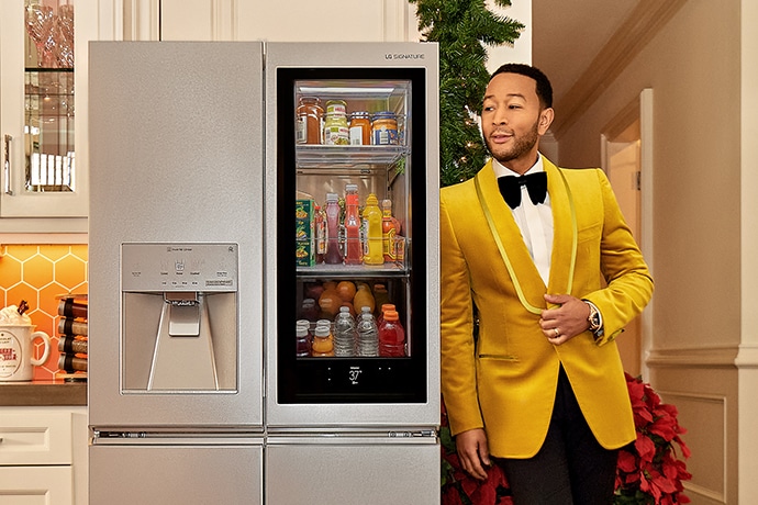 El cantante John Legend apoyado en un refrigerador LG SIGNATURE.