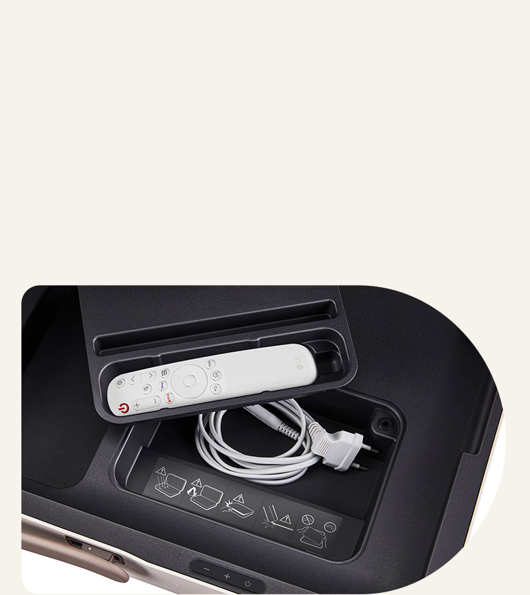 Primer plano de LG StanbyME Go, mostrando los compartimentos integrados. El mando a distancia de LG se encuentra en el compartimento más pequeño y el cable de alimentación, debajo. Dentro del bolsillo hay una etiqueta de precaución.