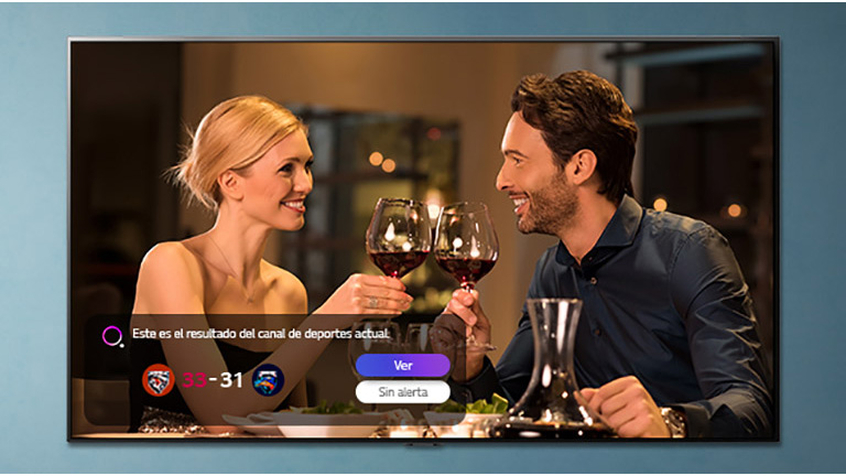 Un hombre y una mujer brindan en una pantalla de TV mientras se visualizan alertas deportivas.