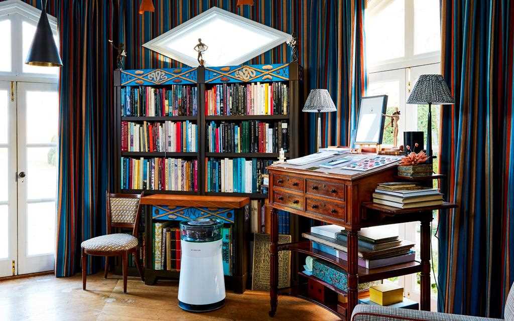 LG SIGNATURE air purifier in an office with a book case and artistic interiors in the background