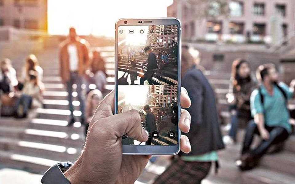 An image of person holding lg g6 to take photography with new square mode feature