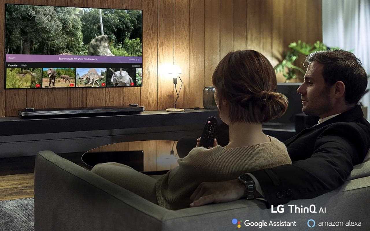 Una pareja se relaja mientras el televisor OLED de LG les ayuda a elegir sus fotos favoritas con la ayuda de Amazon Alexa y el Asistente de Google | Más en LG MAGAZINE