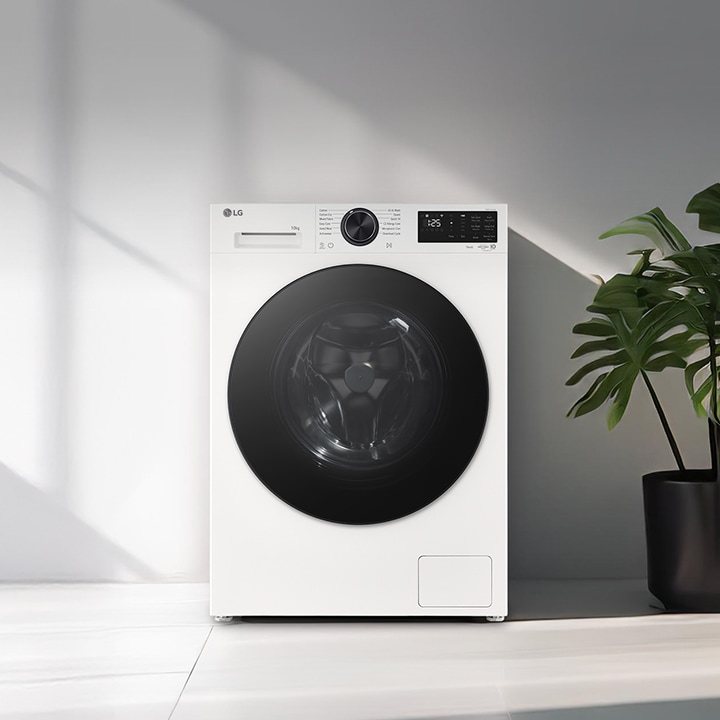 Edestä täytettävä pesukone moderniin pyykinpesutilaan asetettuna