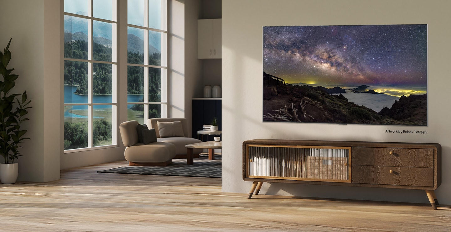 Maaseutukodin sisätilat. Valtavan seinälle kiinnitetyn LG TV:n näytöllä näkyy kaunis luonnonmaisemaa esittävä taideteos. TV näyttää seinälle ripustetulta valokuvalta. 