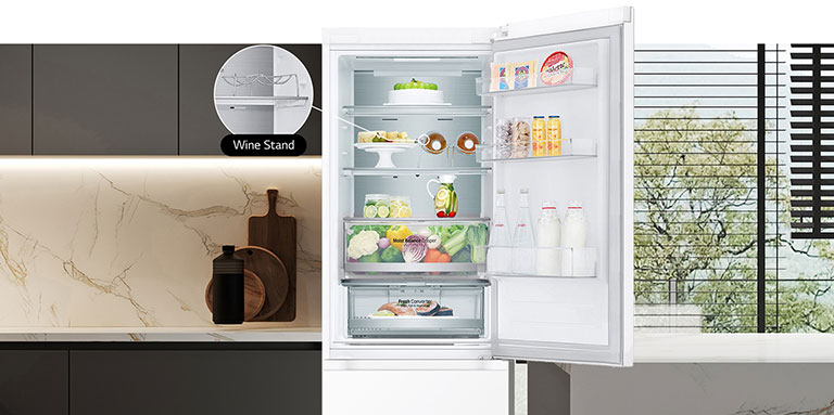 Avoinna oleva jääkaappi, jonka hyllyt on täytetty tuoreilla elintarvikkeilla. Jääkaapissa näkyy viinipulloteline ja taittuva hylly.