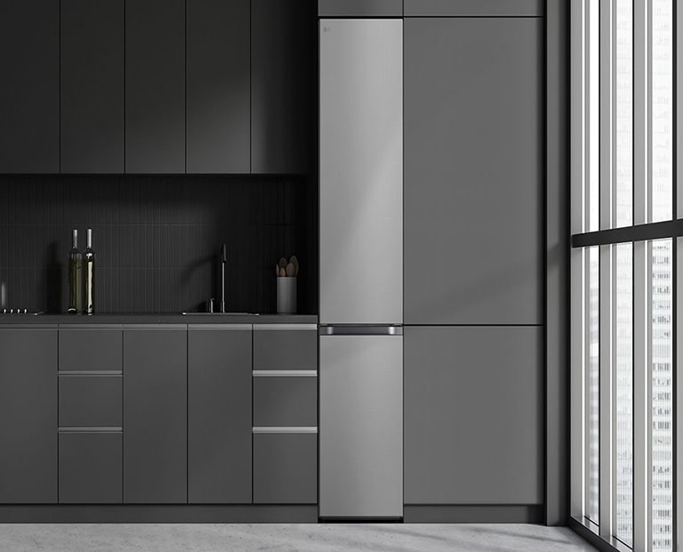 Moderni keittiö, jossa jääkaappi sulautuu keittiökaapistoon ja näyttää sisäänrakennetulta mallilta.