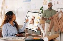 Mies pitelee takkia ja nainen koskee LG Smart Monitor Swingin näyttöä katsoakseen takin tiedot.