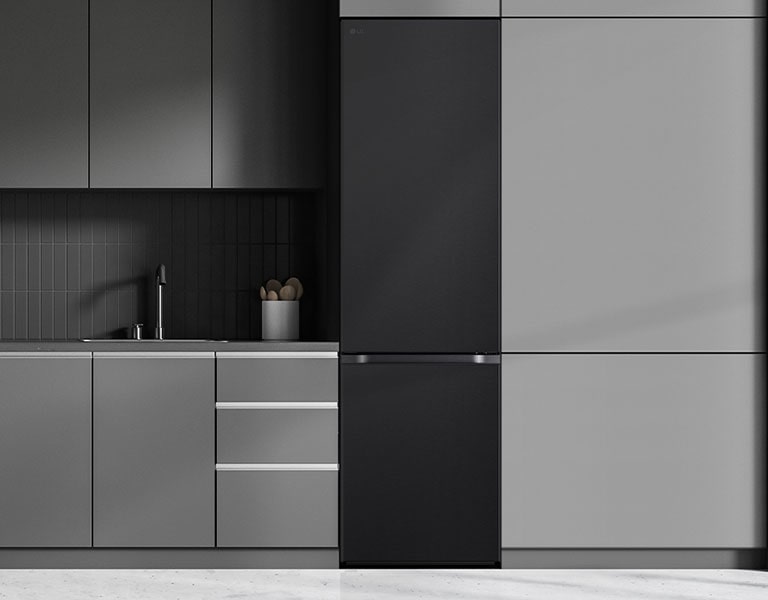 Moderni keittiö, jossa jääkaappi sulautuu keittiökaapistoon ja näyttää sisäänrakennetulta mallilta.