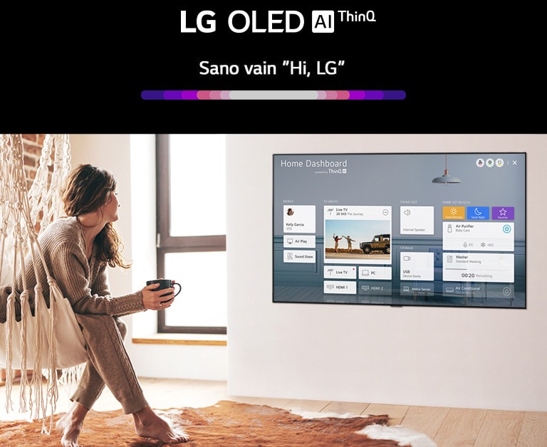 Nainen istuu olohuoneen tuolilla ja televisiossa näkyy Home Dashboard.