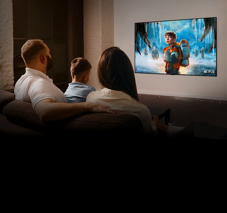 Olohuoneen sohvalla istuu pariskunta katsomassa romanttista elokuvaa televisiosta