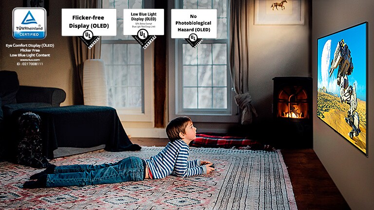 Lapsi makaa lattialla pidellen ohjaussauvaa ja pelaten peliä TV:n kuvaruudussa.