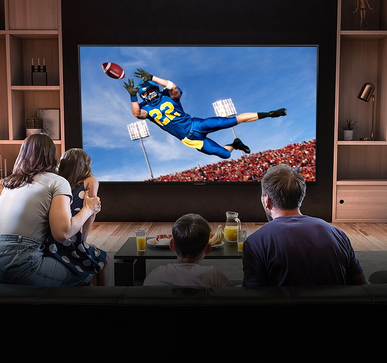 Ihmiset katsovat olohuoneessa Tottenhamin ottelua televisiosta