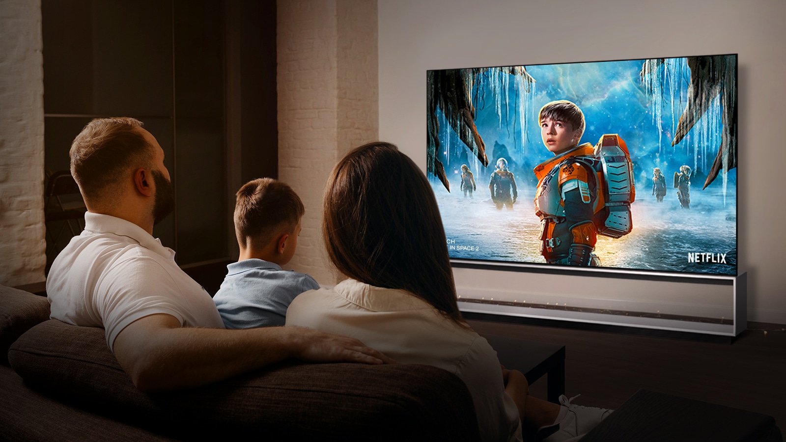 Olohuoneen sohvalla istuu pariskunta katsomassa romanttista elokuvaa televisiosta