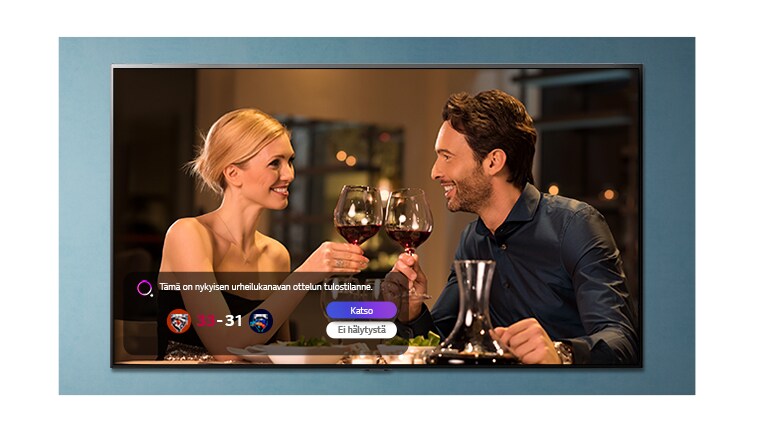 Nainen ja mies kilistelevät laseja TV-näytössä samalla, kun urheiluhälytyksiä näytetään