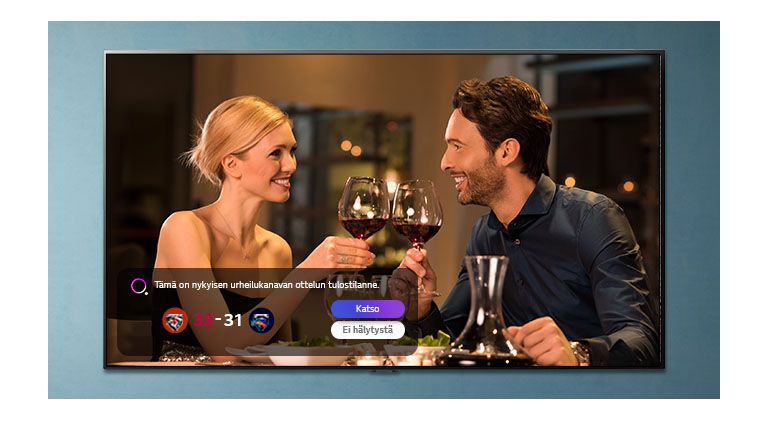 Nainen ja mies kilistelevät laseja TV-näytössä samalla, kun urheiluhälytyksiä näytetään