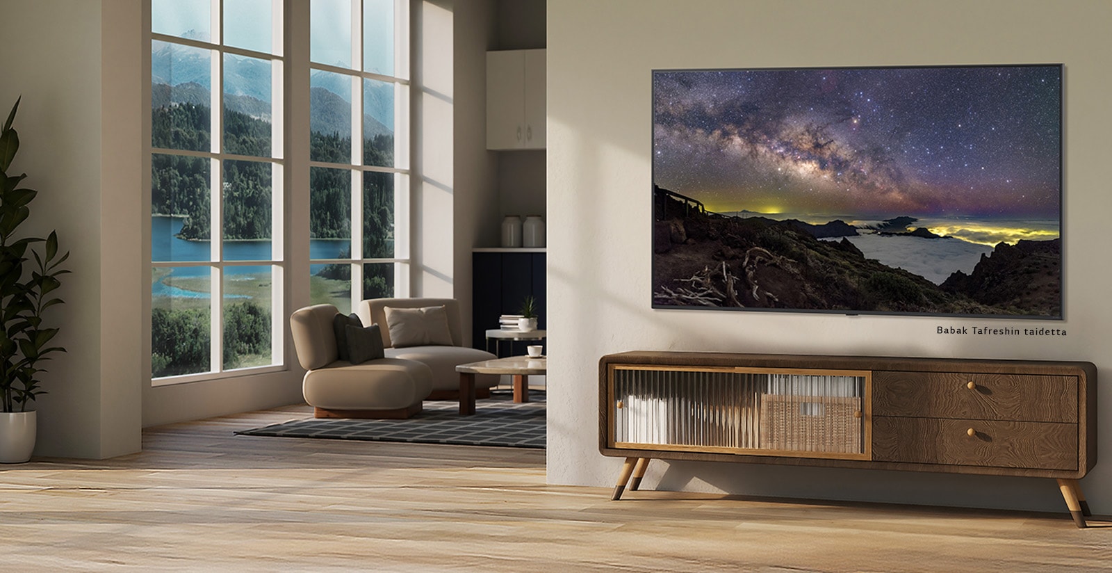 Maaseutukodin sisätilat. Valtavan seinälle kiinnitetyn LG TV:n näytöllä näkyy kaunis luonnonmaisemaa esittävä taideteos. TV näyttää seinälle ripustetulta valokuvalta. 