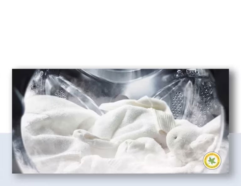 Pesukoneessa on pyykkiä ja käytetään höyryä.