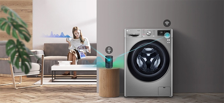 Nainen istuu sohvalla juomassa teetä ja kertoo tekoälykaiuttimelle, mitä pyykinpesukoneen pitää tehdä.