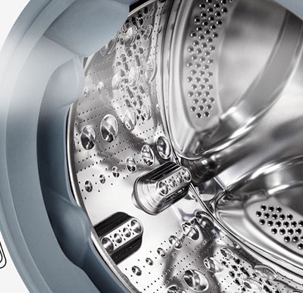 Kuva pesukoneen sisäpuolelta, jossa ruostumattomasta teräksestä valmistetut rummut näkyvät.