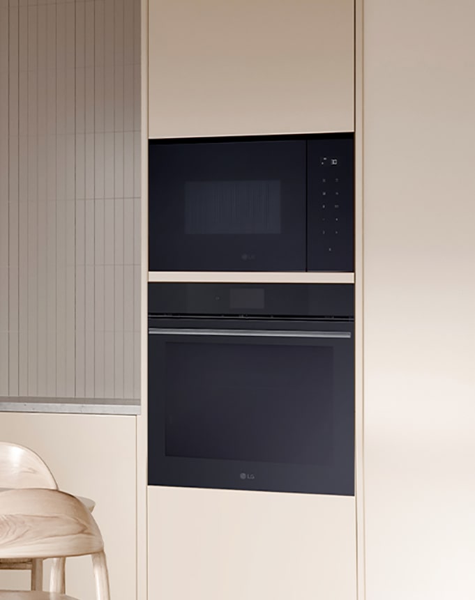 Integroitu mikroaaltouuni on kiinnitetty seinälle, jolla on uuni.