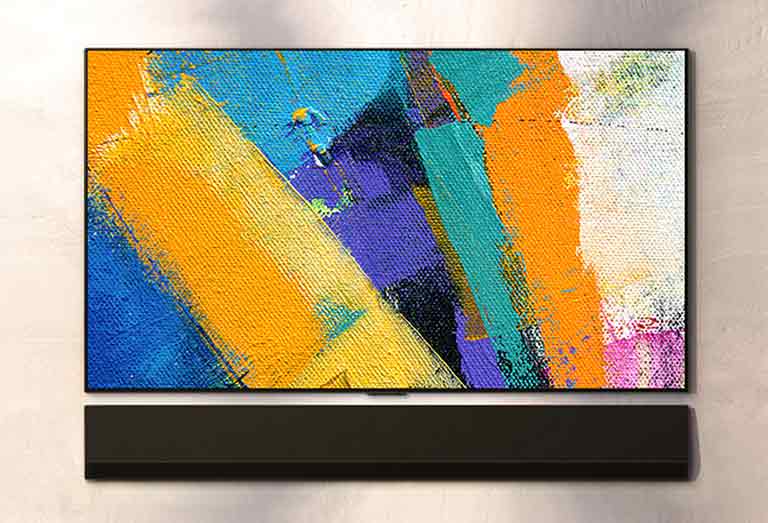 Seinään kiinnitettävä LG Soundbar ja LG TV näkyvät kolmesta kulmasta. TV-ruudussa näkyy monenvärisiä maaleja.