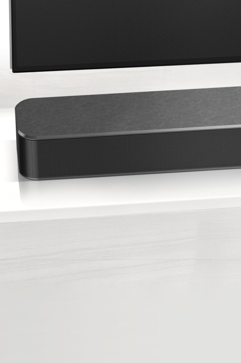Vasemmalla lähikuva LG-soundbar-kaiuttimesta. Television vasen alareuna on myös näkyvissä. 