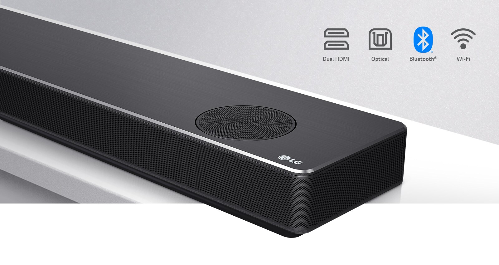 Lähikuva soundbar-kaiuttimen oikeasta reunasta, jonka oikeassa alakulmassa on LG-logo. Liitäntäkuvakkeet näkyvät tuotteen yläpuolella. 