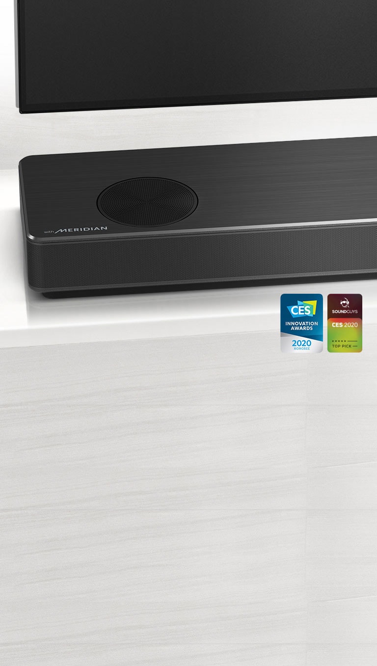 Lähikuva LG-soundbar-kaiuttimen vasemmasta reunasta, jonka vasemmassa alakulmassa näkyy Meridian-logo. Television vasen alareuna on myös näkyvissä. 