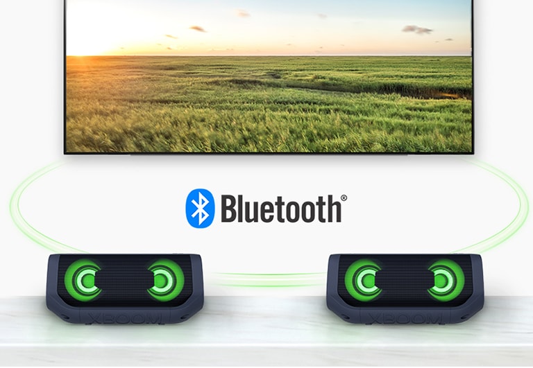 Pöydällä kaksi LG XBOOM Go -laitetta taivaansinisessä valaistuksessa ja niiden takana televisio, jossa näkyy vesiputous.