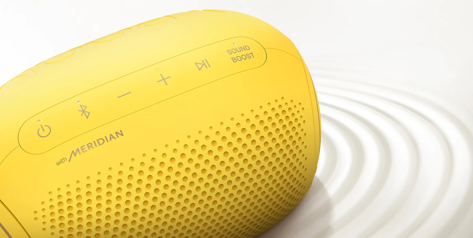 A top view of an LG XBOOM Go PL2S on a white surface with a ripple effect