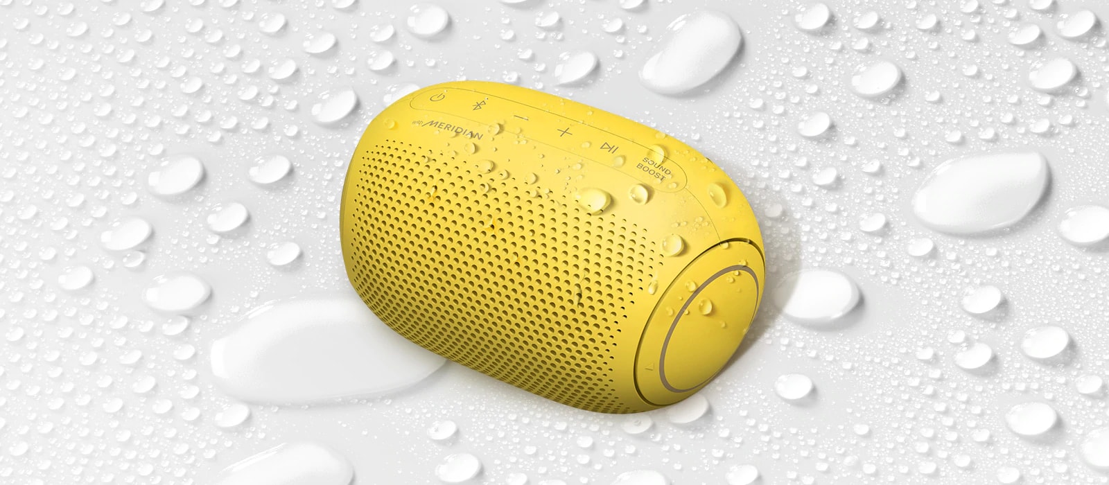 A top view of an LG XBOOM Go on a white surface with water droplets