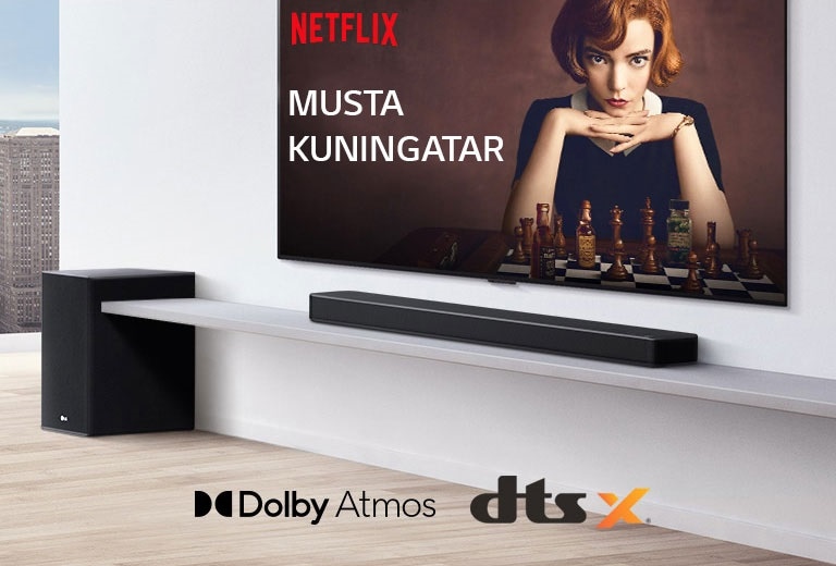 Televisio on seinällä. TV-ruudulla on juliste TV-ohjelmasta. LG Soundbar on TV:n alapuolella oikealla valkoisella hyllyllä ja alibassokaiutin on vieressä oikealla. Dolby Atmos- ja DTS:X -logo kuvan alhaalla keskellä.