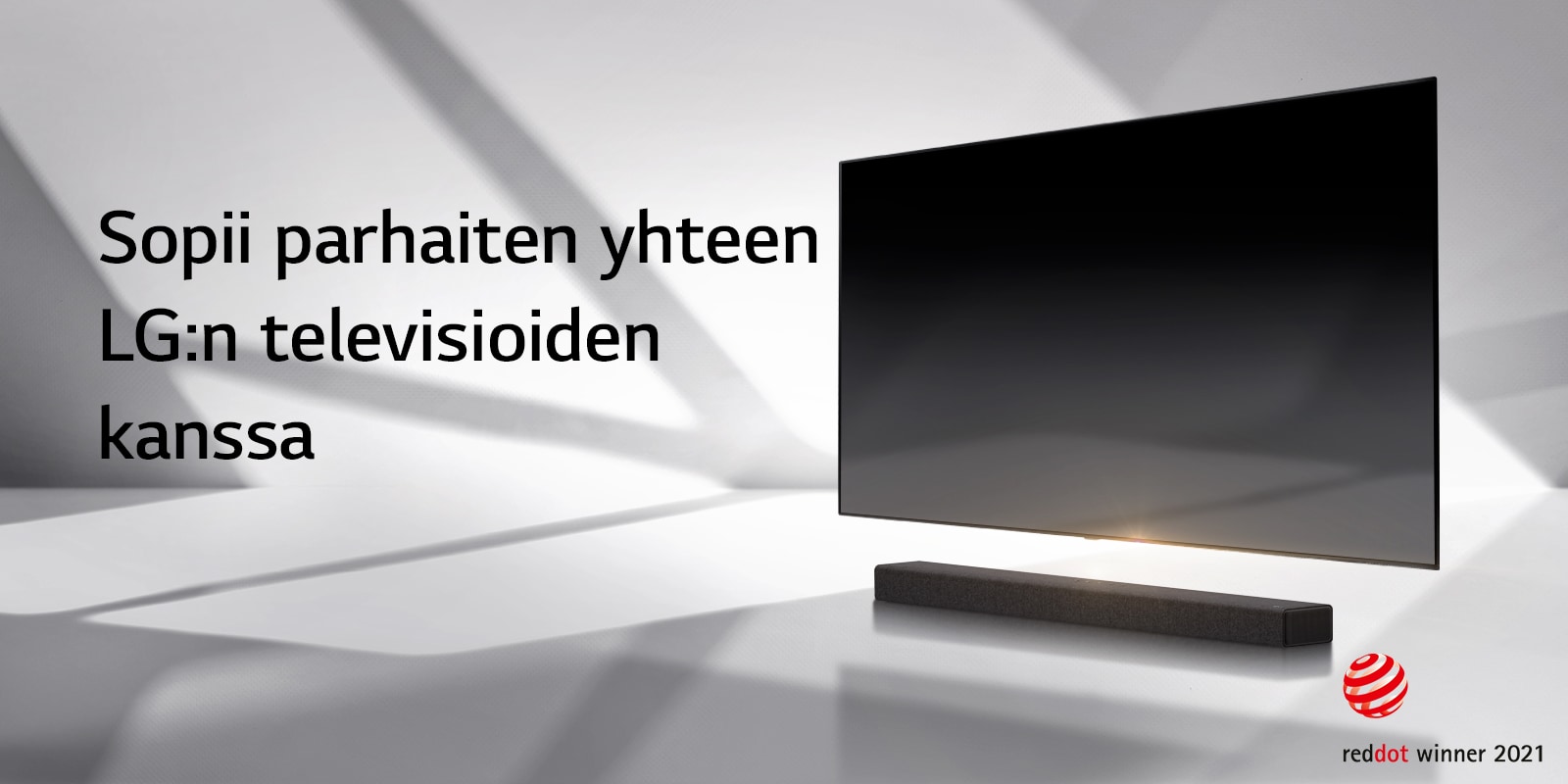 Soundbar-kaiutin ja TV ovat valkoisella lattialla ja ulkoa oikealta takaa tulee varjo.