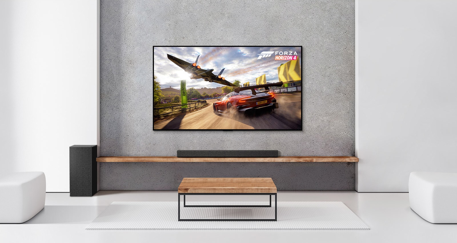 Kaksi takakaiutinta, alabassokaiutin, soundbar-kaiutin ja TV ovat valkoisessa olohuoneessa TV-ruudulla ajava auto ja avaruusalus