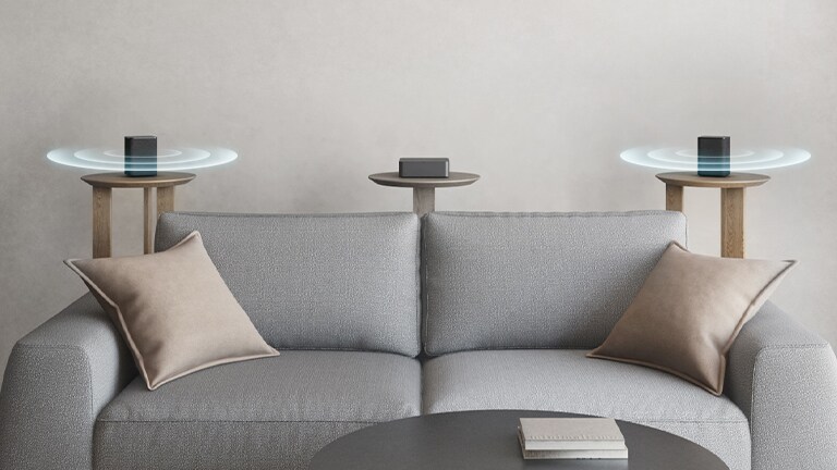 Kaksi takakaiutinta on sijoitettu sohvan vasemmalle ja oikealle puolelle. Ääniaaltografiikat tulevat ulos takakaiuttimista.