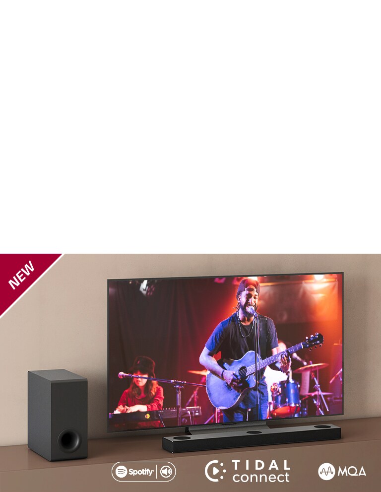 LG TV on asetettu ruskealle hyllylle, ja LG Sound Bar S80QY on asetettu TV:n eteen. Subwoofer on asetettu TV:n vasemmalle puolelle. Televisiossa näkyy konserttinäkymä. UUSI-merkki näkyy vasemmassa yläkulmassa.