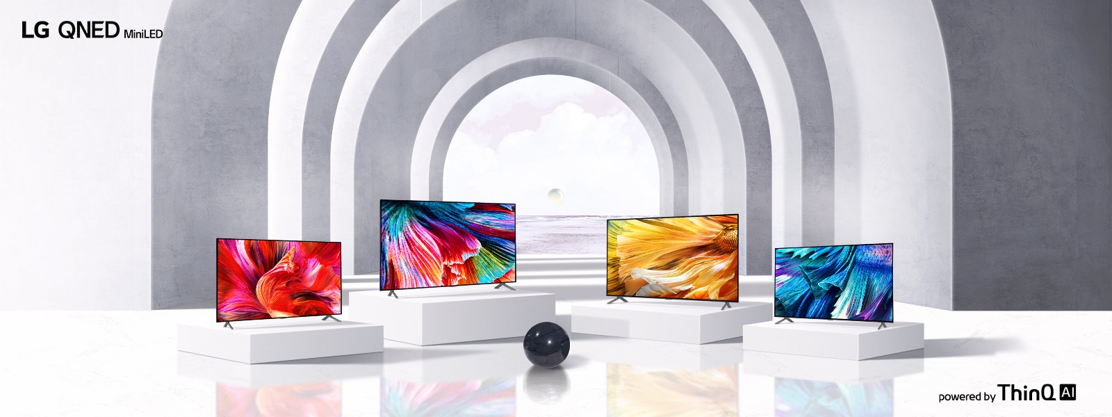 Kuva neljästä erikokoisesta LG QNED MiniLED -televisiosta, jotka on järjestetty valkoisille alustoille vaaleaan avoimeen tilaan, joka on peitetty kaarilla, ja jossa on musta pallo televisioiden edessä.