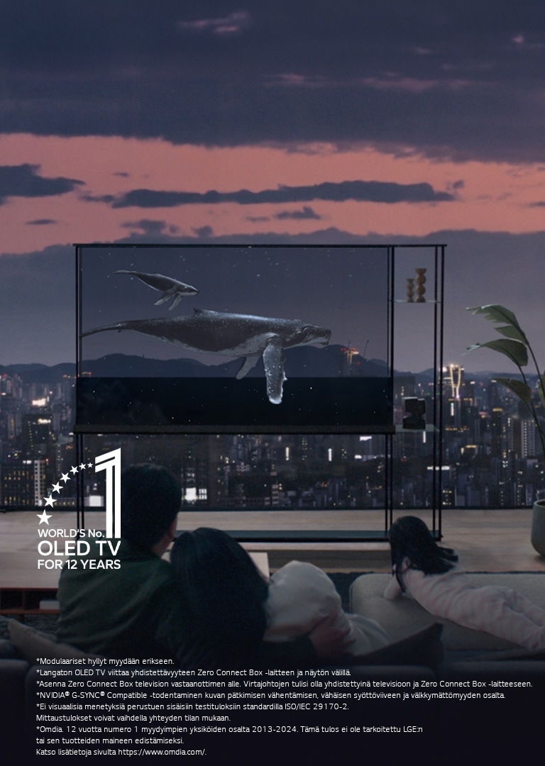 Valas ui LG SIGNATURE OLED T -ruudun poikki ja kaihtimet on nostettu niin, että ikkunasta näkyy iltainen kaupunkimaisema. Ihmiset istuvat sohvalla katseet kohti televisiota ja ikkunaa. Zero Connect Box on pienellä pöydällä television vasemmalla puolella. 