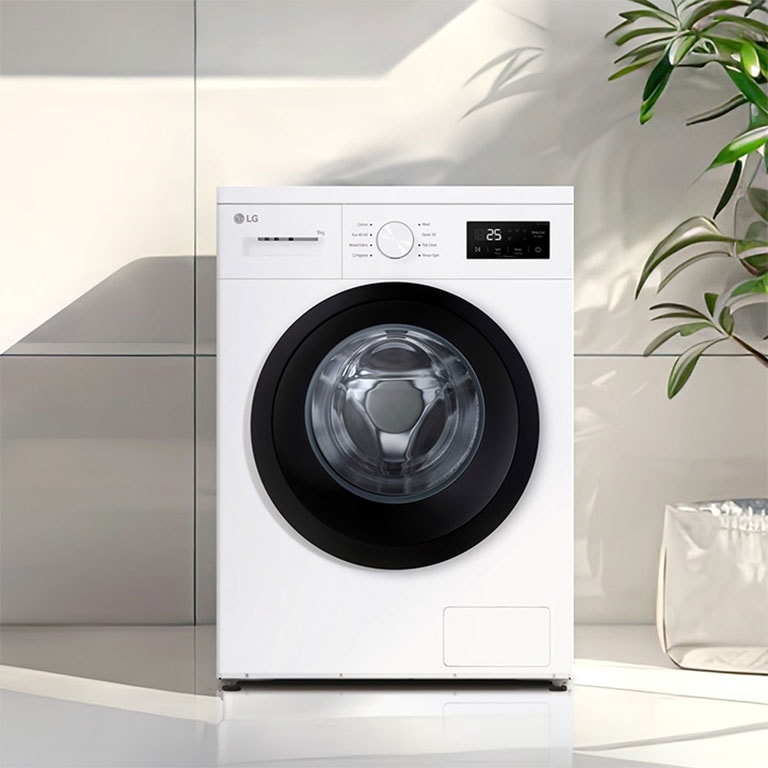  Edestä täytettävä pesukone moderniin pyykinpesutilaan asetettuna