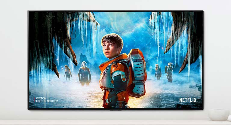 Kohtaus sarjasta Lost in Space 2, jossa päähenkilöt tuijottavat tiiviisti TV-ruutua.