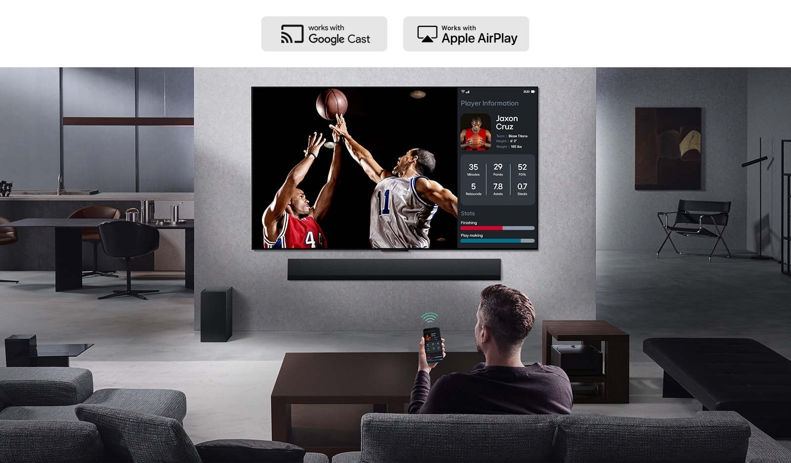 Henkilö olohuoneessaan pitelee puhelintaan. Puhelimella näkyy lähetyskuvake, joka näyttää, että puhelimen näyttöä peilataan TV:seen. TV:ssä näkyy koripallopeli peilatun näytön vieressä, jolla näkyy pelaajatilasto.