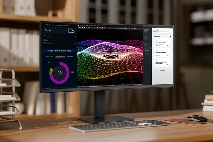 Un espace de travail à domicile moderne doté d’un moniteur LG ultra large affichant des tableaux de bord de données, des graphiques 3D et des outils de gestion de projet, avec un clavier et une souris sans fil sur un bureau en bois.	