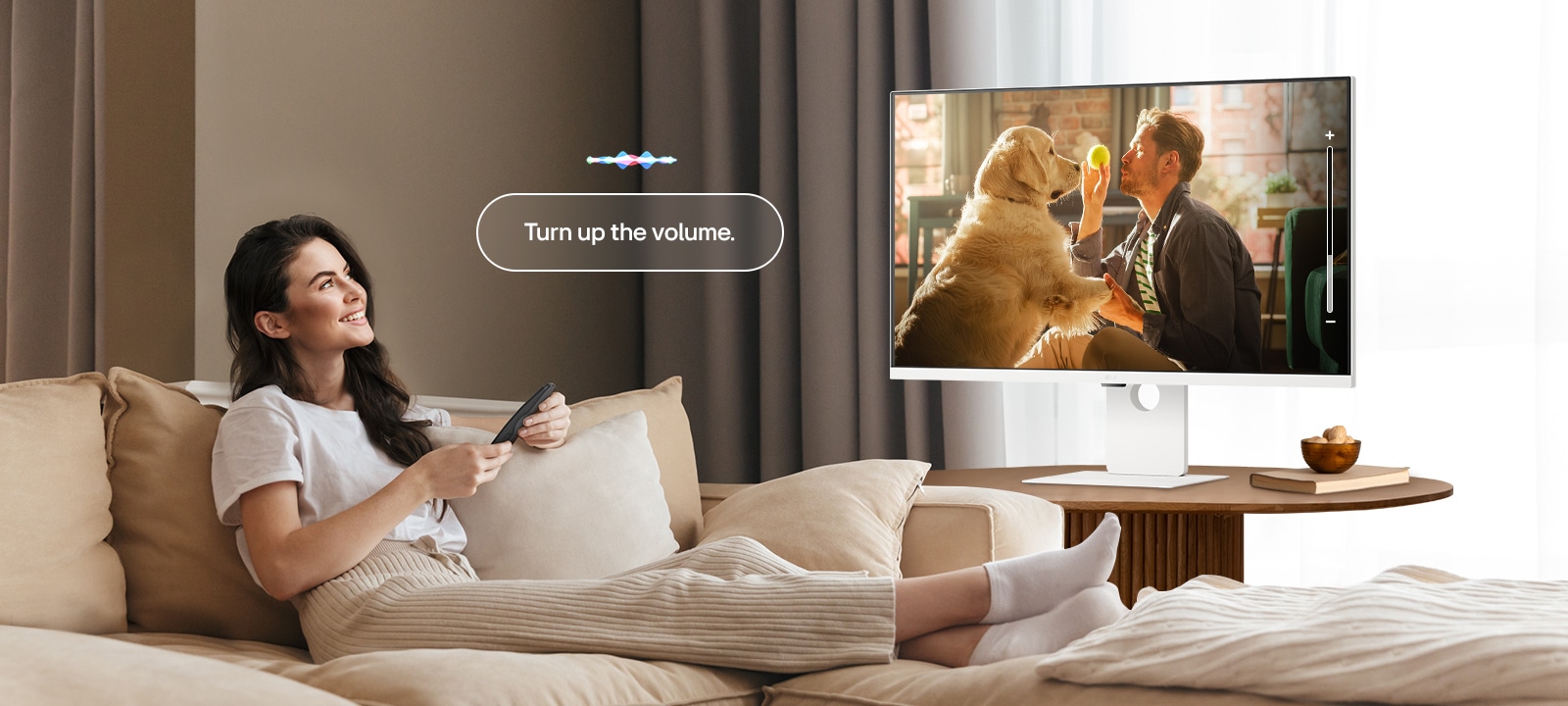 Nainen lisää LG Smart Monitor -näytön äänenvoimakkuutta Magic Remotella.	