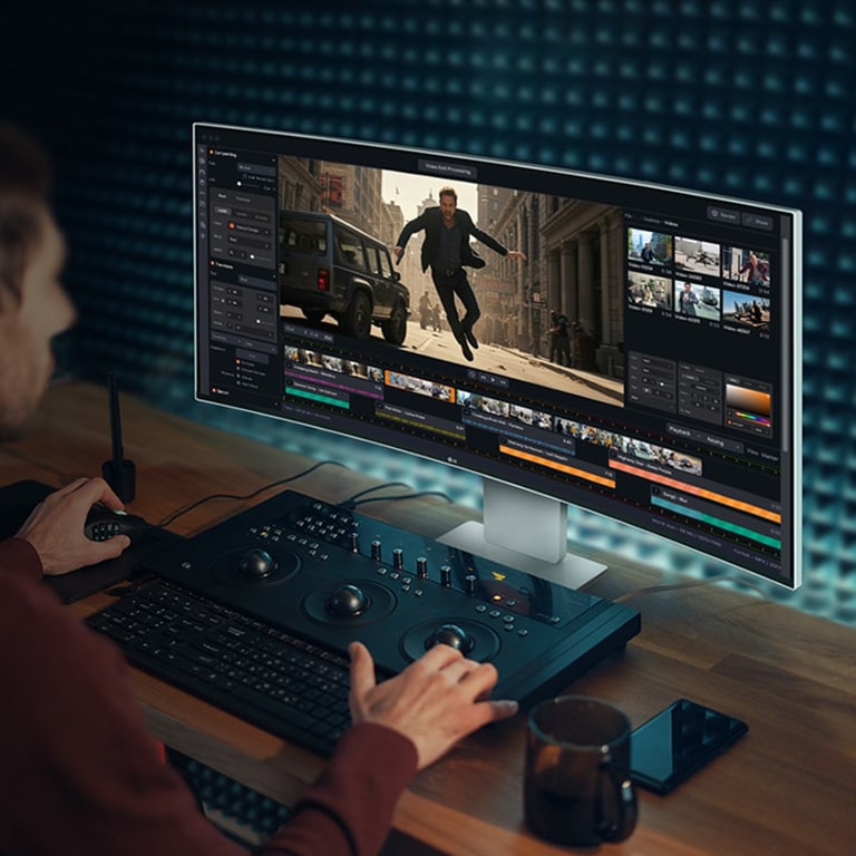 Henkilö työskentelee videonluontiohjelmalla UltraFine-näytöllä.